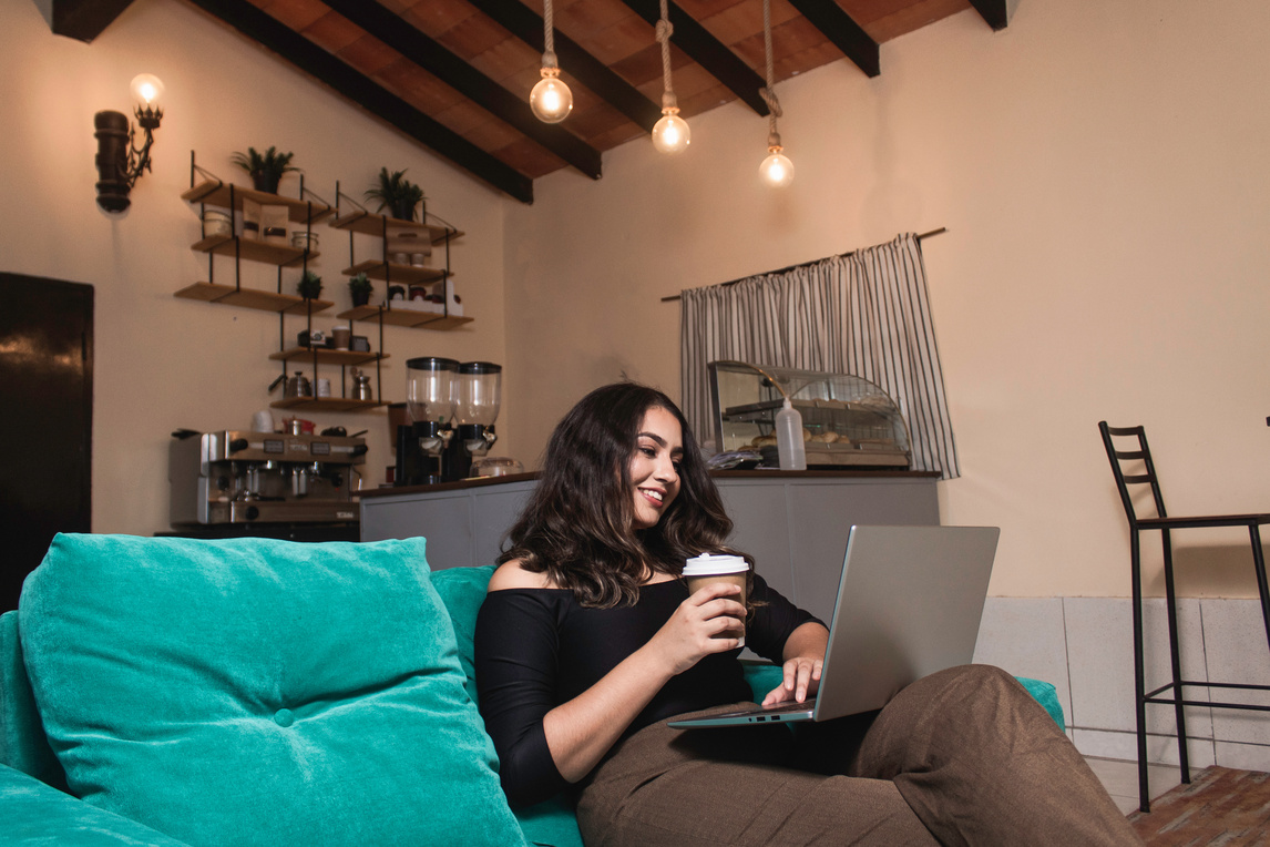 A young woman sitting at a desk with a laptop and looking ahead.